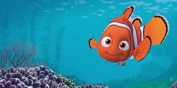Imagem da animação Procurando Nemo. À direita da cena, Nemo aparece sorrindo levemente, com os olhos voltados para a frente. Sua nadadeira direita é visivelmente menor que a esquerda, característica que o diferencia ao longo da história. Ao fundo, vê-se um ambiente marinho em tons de azul. Na parte inferior da imagem há diferentes corais em tons de roxo, rosa e cinza, além de vegetação marinha ao fundo, desfocada, sugerindo profundidade. Reprodução/Pixar